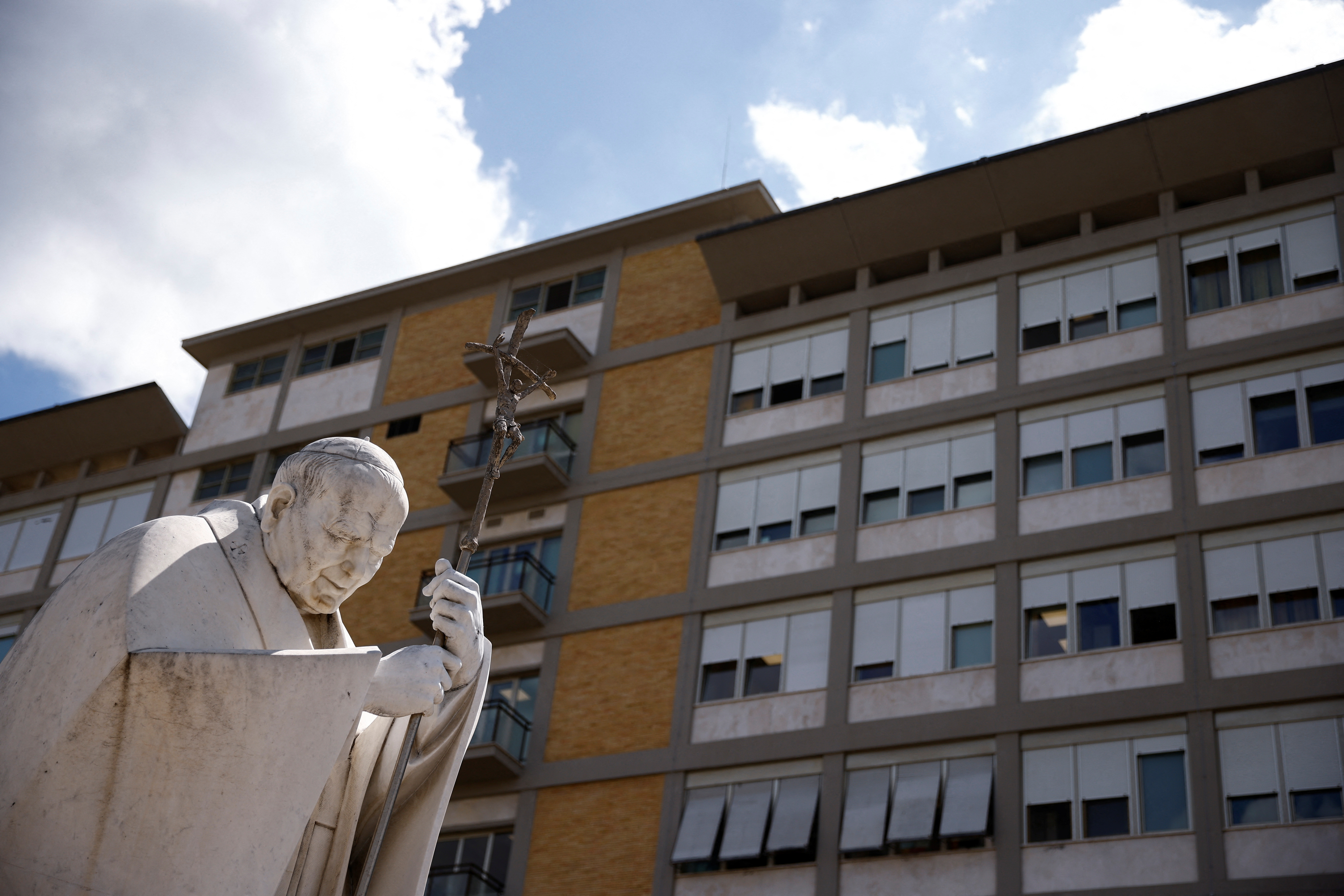 Una estatua del papa Juan Pablo II frente al hospital Gemelli, donde está internado en papa (REUTERS/Guglielmo Mangiapane)